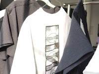 black and white t - shirts hanging on a rack