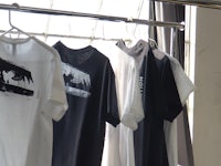 black and white t - shirts hanging on a rack