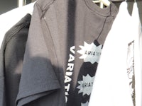 black and white t - shirts hanging on a rack