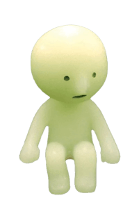 a green toy figure sitting on top of a black background