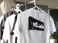 a black and white t - shirt hanging on a rack